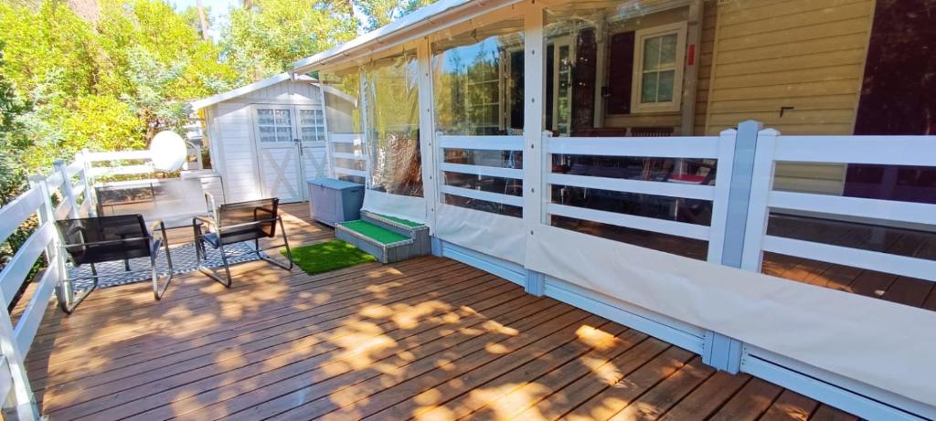 a screened porch with a white fence on a house at La Cabane de Nell in Lège-Cap-Ferret