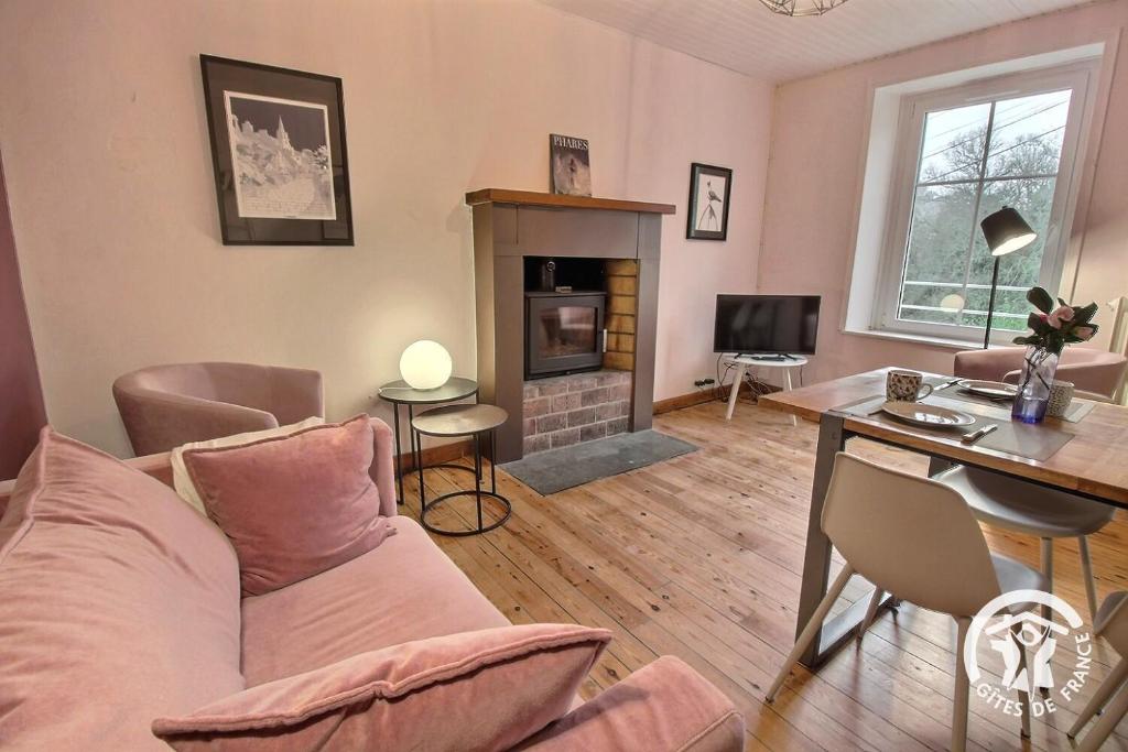 a living room with a couch and a fireplace at Ty amzer'zo in Ploulech