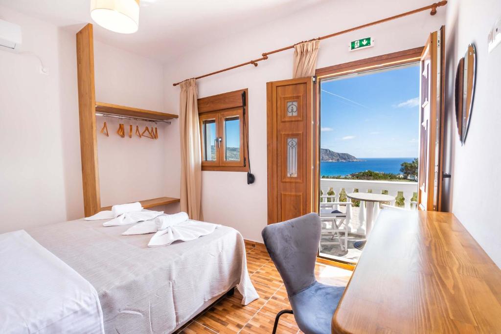 a bedroom with a bed and a table and a window at Enalia Suites in Amoopi