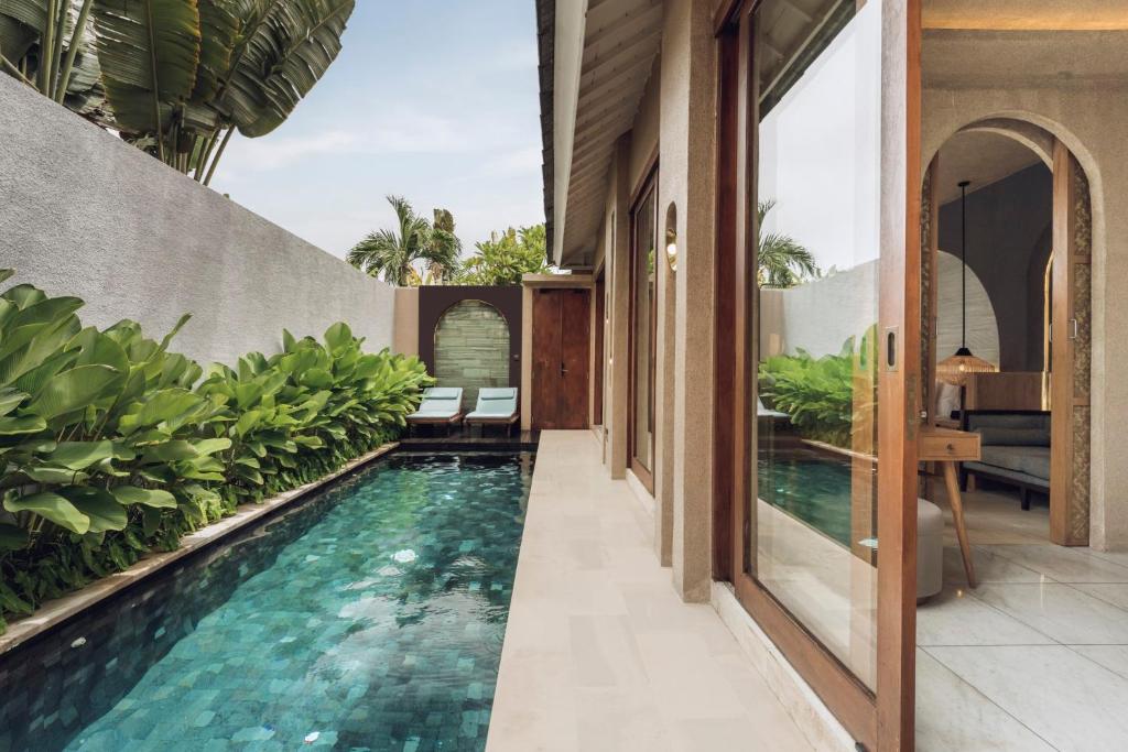 an infinity pool in the middle of a house at Astera Villa Seminyak by Ini Vie Hospitality in Seminyak