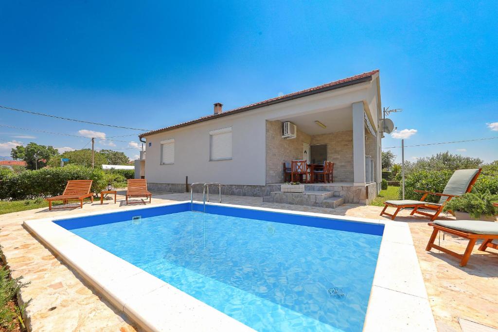 a swimming pool in front of a house at Eda in Vrsi