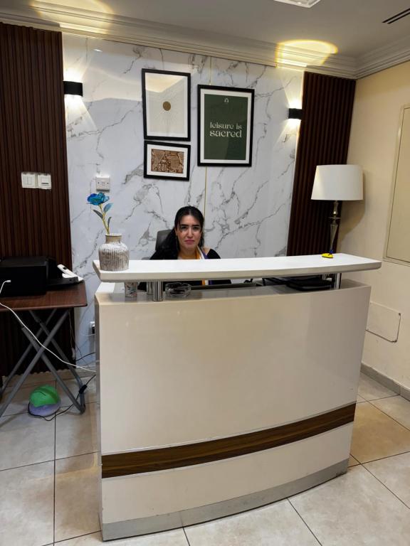 a woman sitting at a counter in an office at Deira Guest house by PHM in Dubai