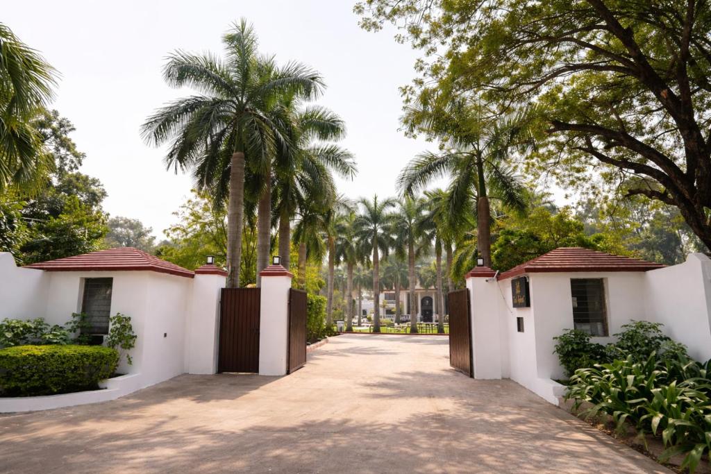 a gate to a villa with palm trees at Tivoli Bijwasan in Jāmb