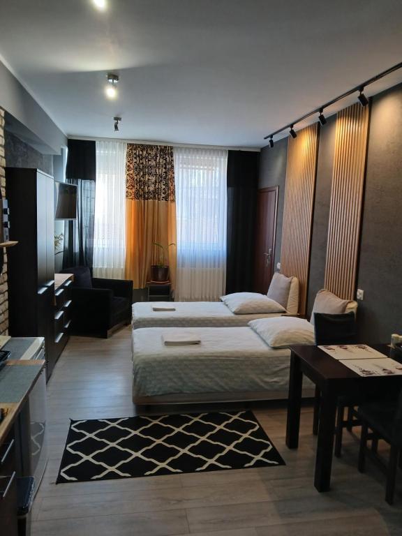 a hotel room with two beds and a table at Noclegi nad Morzem u Kasi in Gdańsk