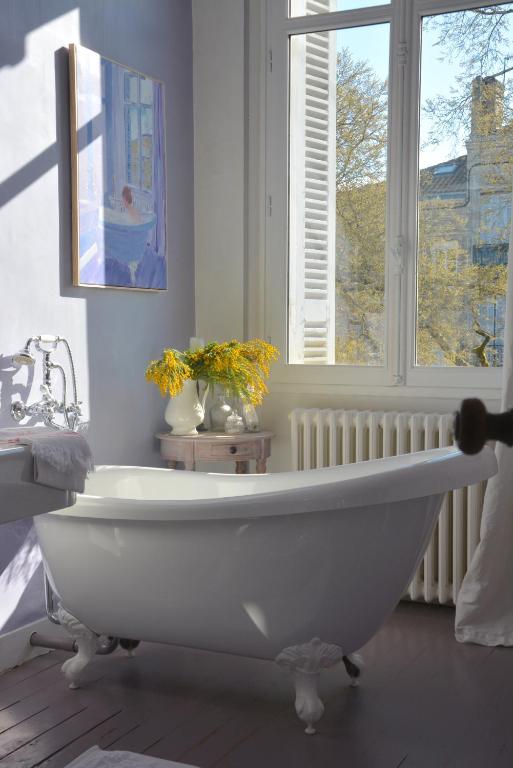 a white bath tub in a bathroom with a window at la maison, chambre d'hôtes de charme et atelier d'artiste, Libourne saint Emilion in Libourne