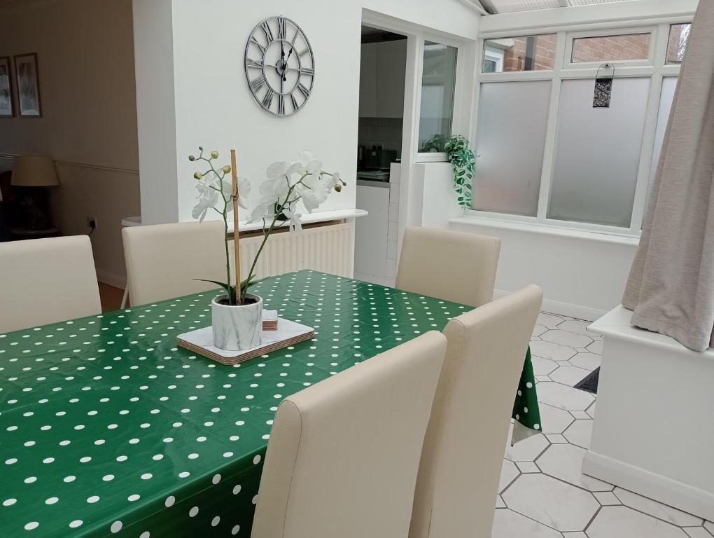 a dining room with a green table with white polka dots at 3BR House with garden near Bicester Village in Bicester