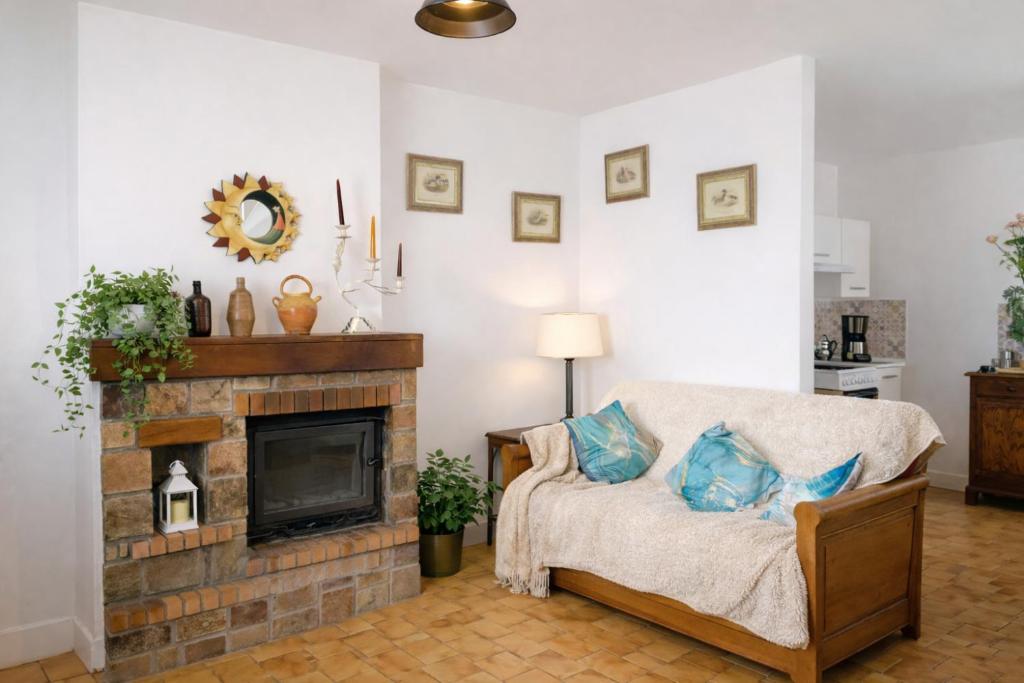 a living room with a couch and a fireplace at Maison entière pour 4 personnes avec parking proche centre ville in Saint-Sulpice-sur-Risle