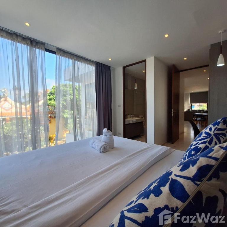a bedroom with a large bed with a large window at White Cube House in Nathon Bay