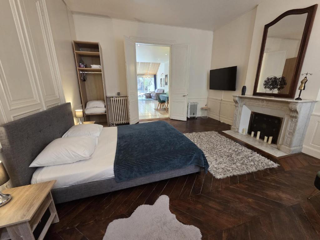 a bedroom with a large bed and a fireplace at Résidence Austerlitz centre Angouleme in Angoulême