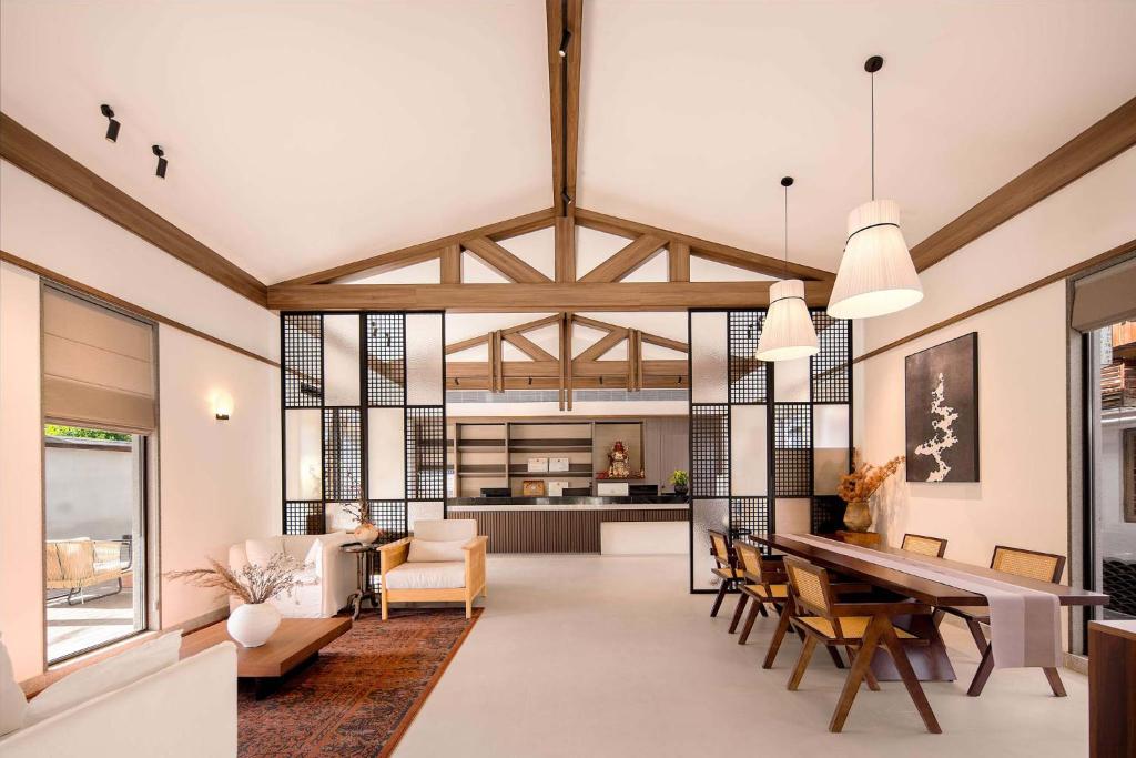 a dining room and living room with a table and chairs at ZSZ Hot Spring Resort in Shajing