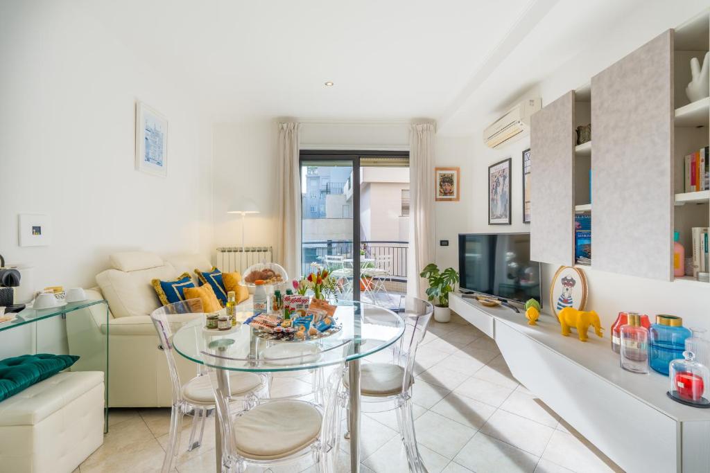 a kitchen and living room with a glass table and chairs at Suite Des Etrangers -Parcheggio privato- Private parking in Sanremo