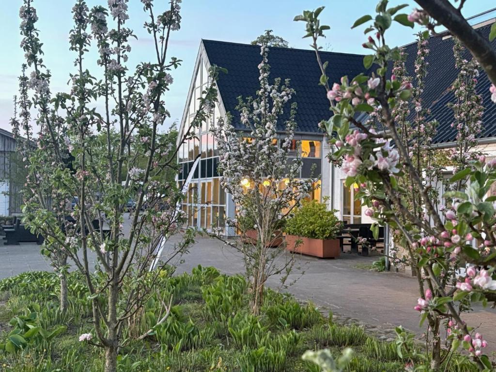 a building with trees and flowers in front of it at Tollundgaard Golf Park & Apartments in Funder Kirkeby