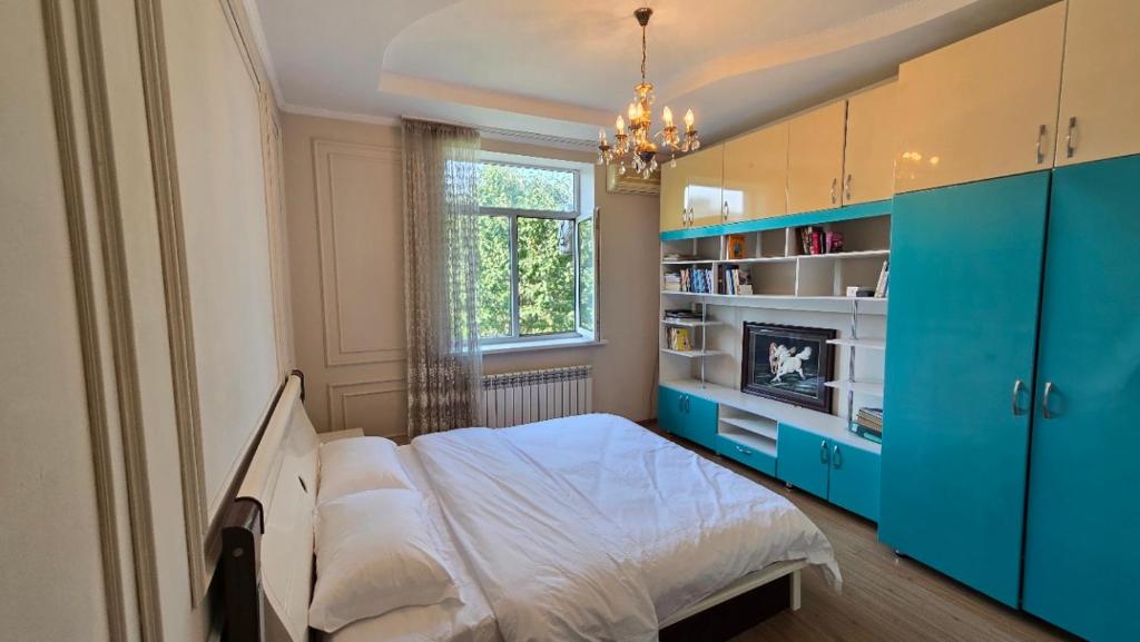 a bedroom with a bed with blue cabinets and a window at 华人民宿 in Almaty