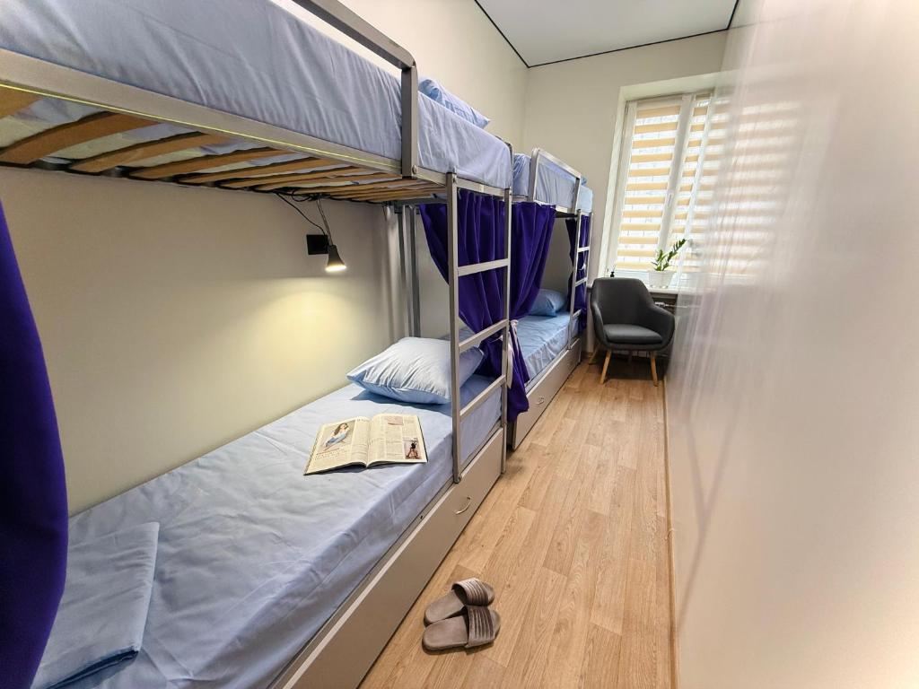 Ein Schlafsaal mit zwei Etagenbetten und einem Stuhl in der Unterkunft Kust Hostel in Kiew
