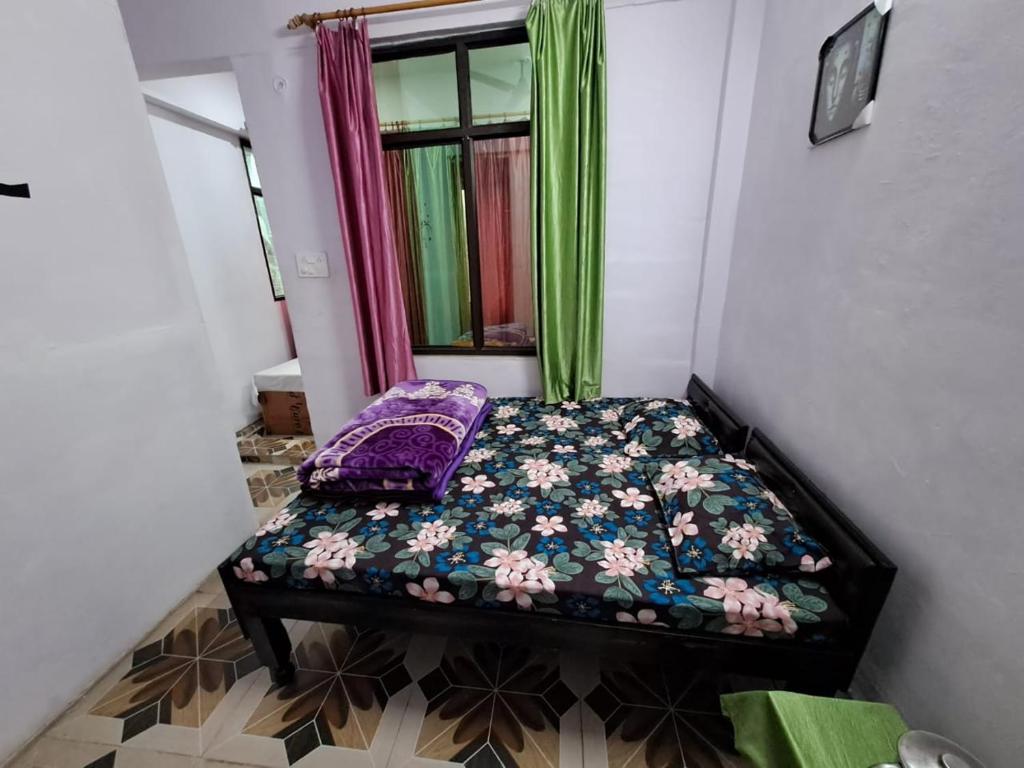 a small bed in a room with a window at Hotel Himalayan dews in Ukhimath