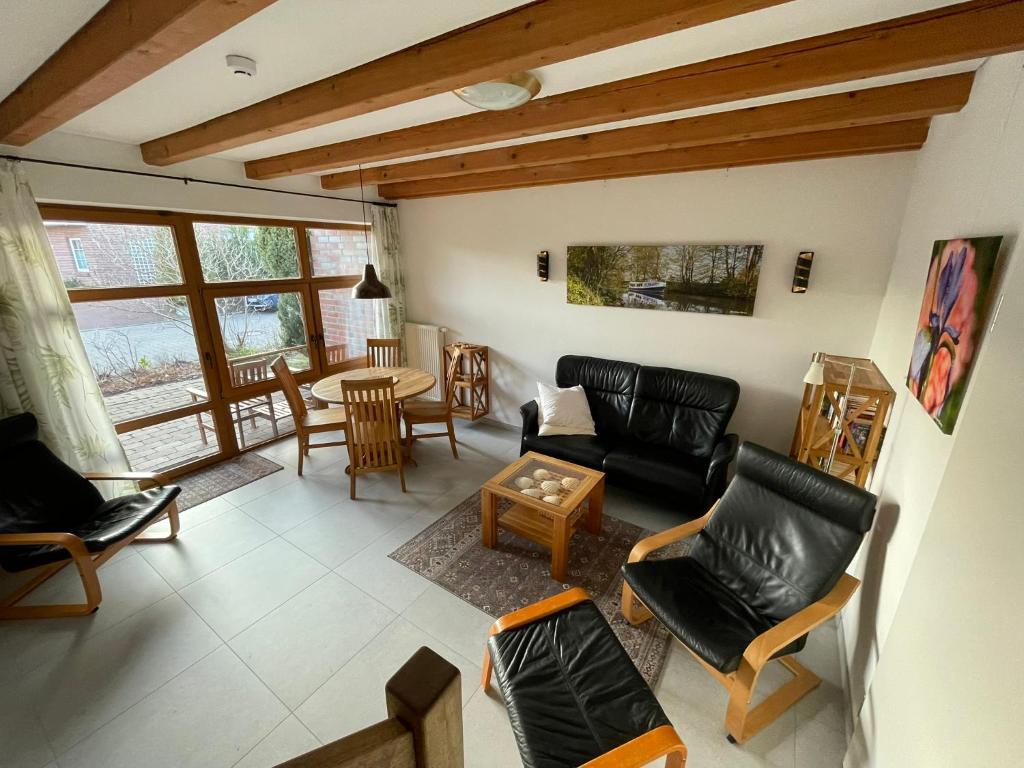 a living room with leather furniture and a table at Ferienhaus Uferweg in Otterndorf