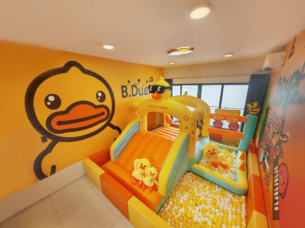 a childs room with a toy bed and a yellow wall at Naughty Castle Playground & Ball Pool in Johor Bahru