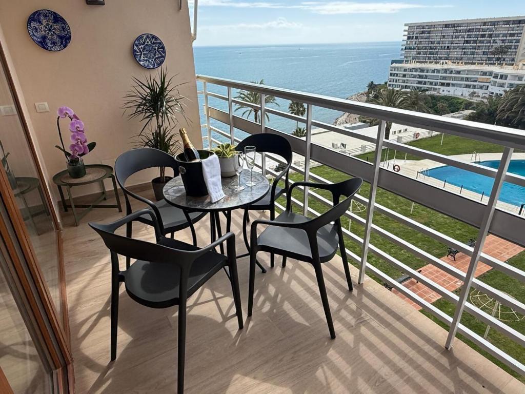 a balcony with a table and chairs and the ocean at La Roca Sea View Luxury Apartment Beach Elevator in Torremolinos