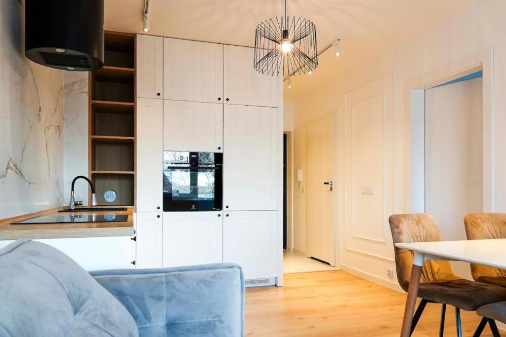 a kitchen with a table and a white cabinet at Sami Swoi 1 in Bełchatów