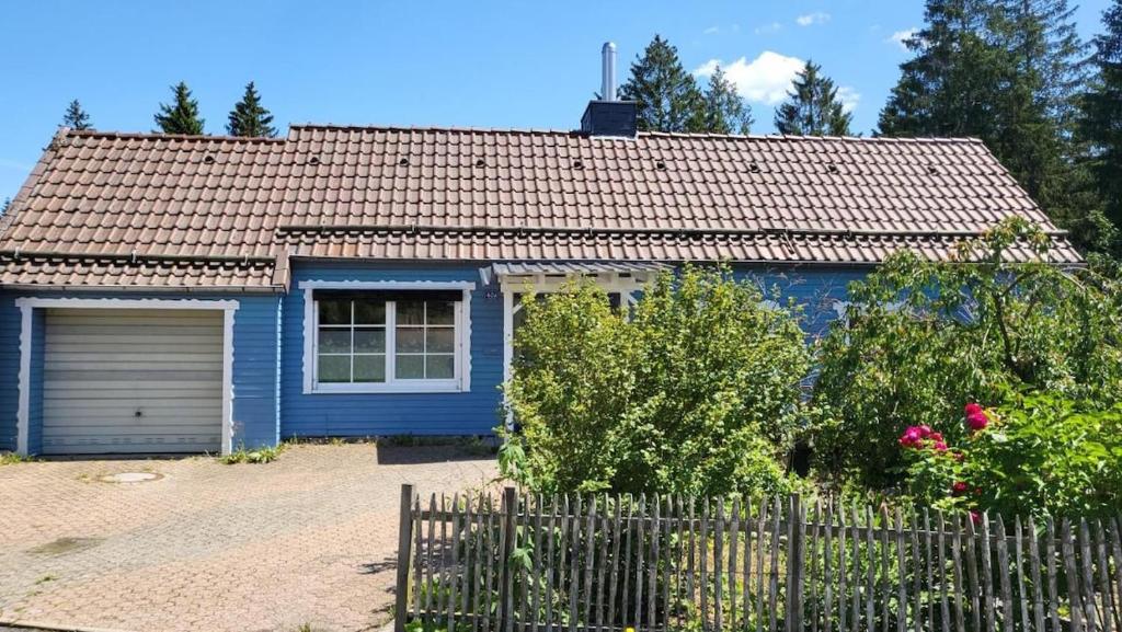 a blue house with a fence in front of it at Hearts Home Hahnenklee in Hahnenklee-Bockswiese
