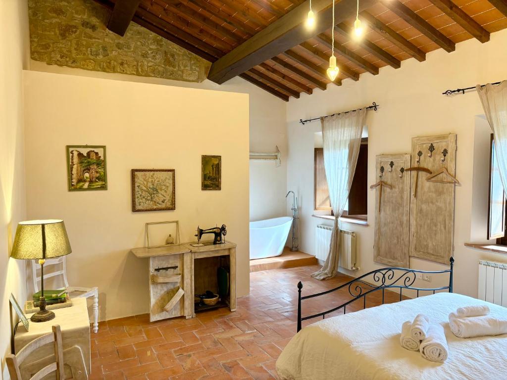 a bedroom with a bed and a bathroom with a tub at Vitalenta Agriboutique in Pienza