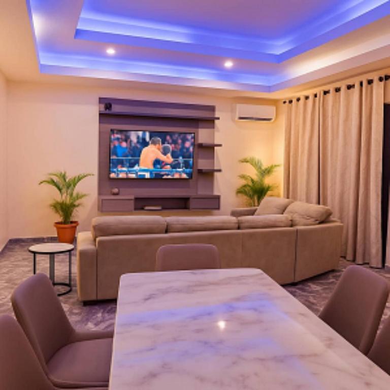 a living room with a couch and a tv at 154 Apartments and Hotel in Abuja