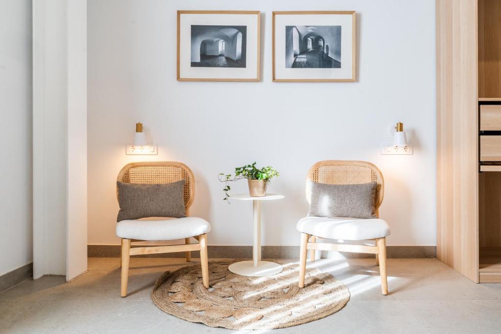 two chairs and a table in a room at Apartamentos Territorios in Mérida