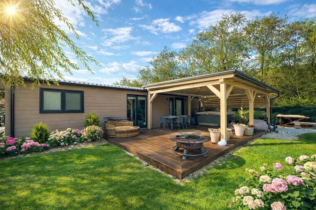 a backyard with a wooden deck with a pergola at Woodland cottage in Balatonfůzfő