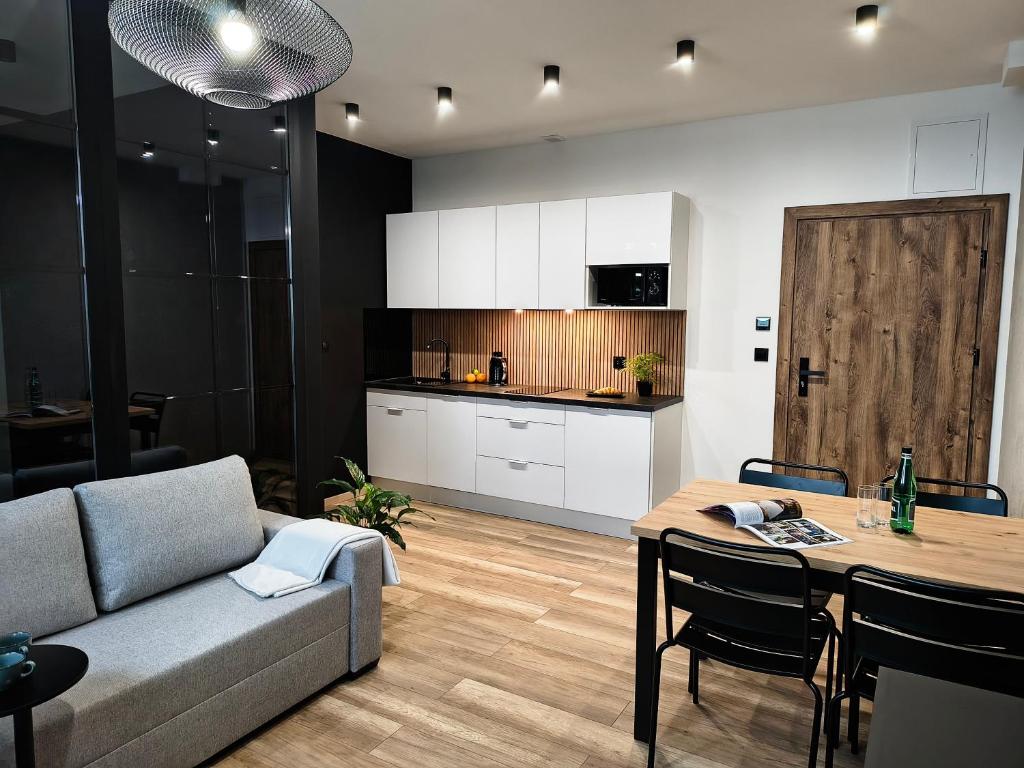 a living room and kitchen with a couch and a table at Nowe apartamenty SOLAR, Padel & Tenis, Parking, Blisko centrum in Bielsko-Biała