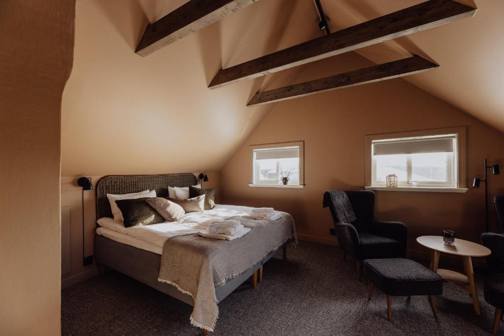 a bedroom with a bed and two windows at Trakt Forest Hotell Gårdshotell in Holsbybrunn