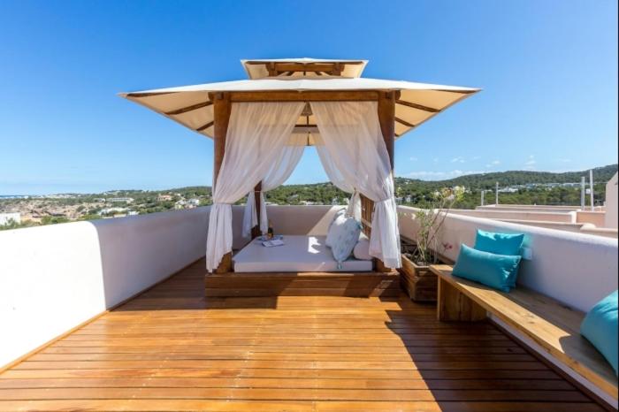 a wooden deck with a canopy on a balcony at Can Tau Cala Tarida in Sant Josep de sa Talaia