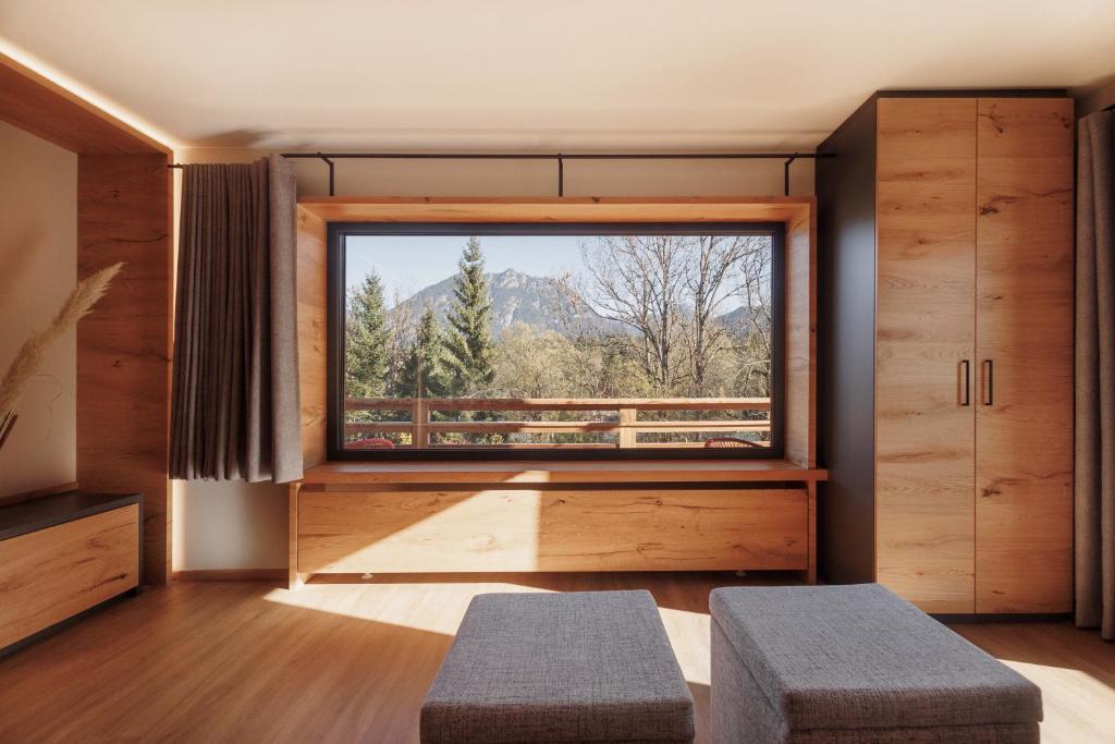 a room with a large window and two benches at Alpenchalet am Lech in Ehenbichl