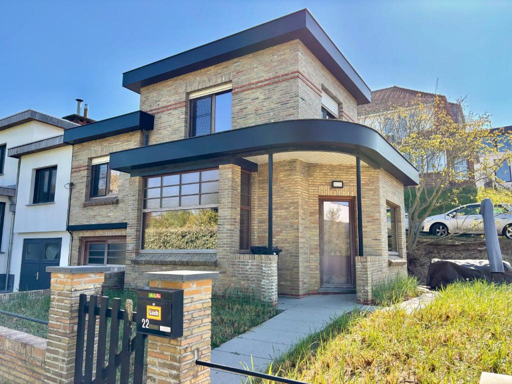 a brick house with a black roof at Villa Bonheur in Koksijde