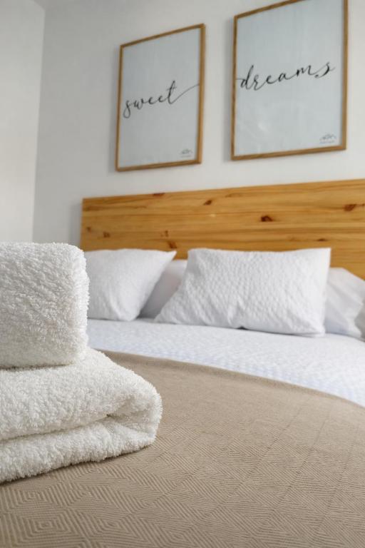a bedroom with two beds with white sheets and pillows at Sentir CAZORLA in Cazorla