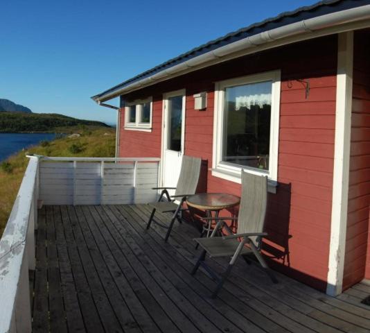a house with two chairs and a table on a deck at Guesthouse in Hellosan in Vestvågøya