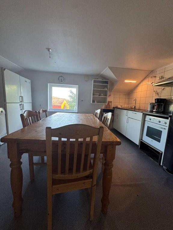 a kitchen with a wooden table and chairs in it at Workers Stay - Worker Accommodation Torslanda - Volvo - Sweden in Gothenburg