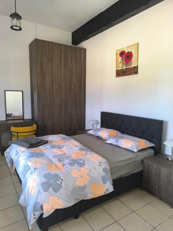 a bedroom with a bed with a floral bedspread at Drouseia Karithea House in Drousha