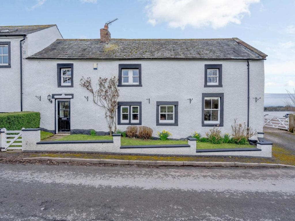 a white house with black windows on a street at 4 Bed in Wigton oc-79563 in Calvo