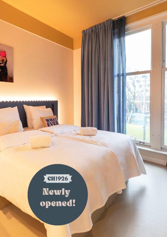 a bedroom with a bed with a sign on it at City Hotel Rembrandt Square - Just renovated in Amsterdam