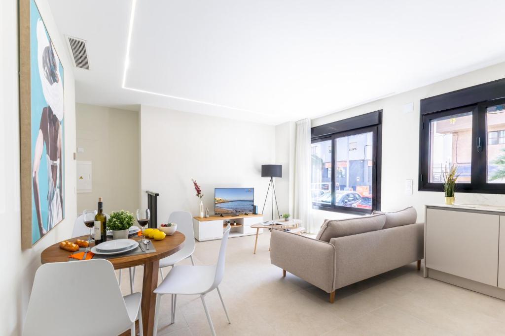a living room with a table and a couch at Brisamar Suites I by VillaGranCanaria in Arinaga