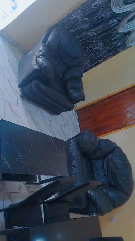 a statue of a hand holding a gun on a wall at Secka Apartment in Sukuta