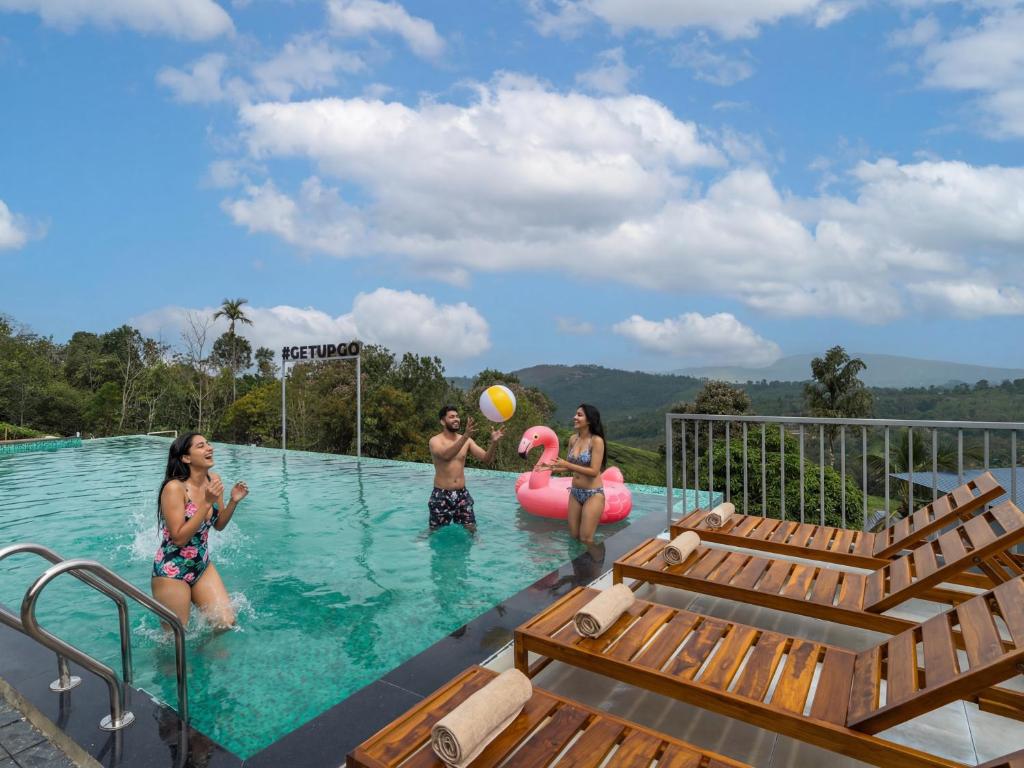 a group of people playing with a frisbee in a swimming pool at The Hosteller Bam Vagamon in Vagamon