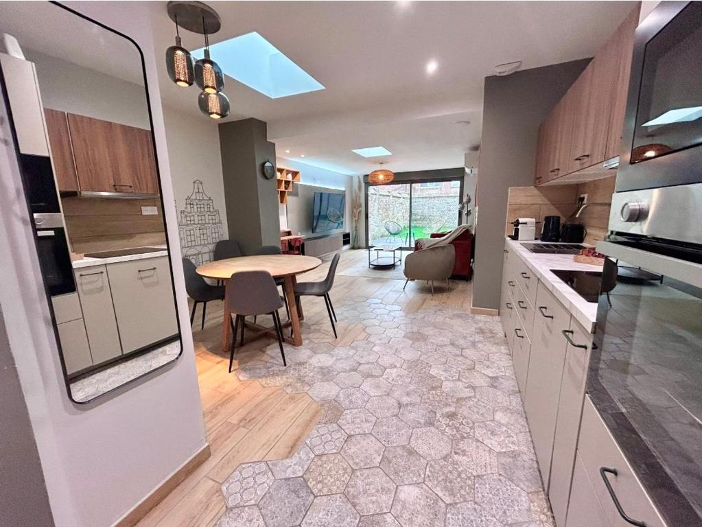 a kitchen with a table and a dining room at Charmant appartement plain-pied avec accès facile in Bailleul