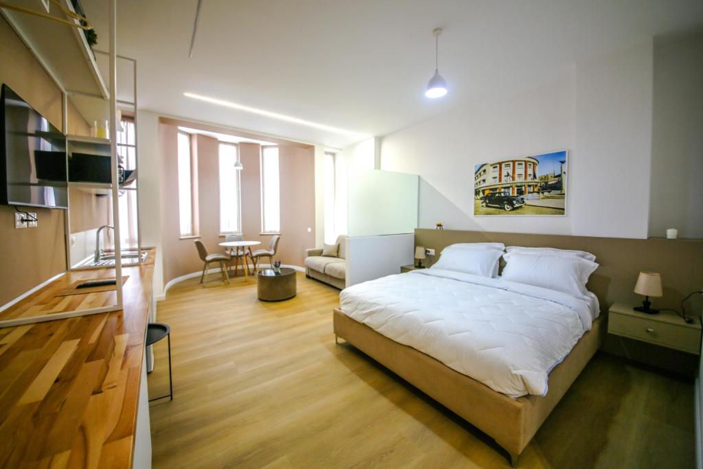 a bedroom with a large bed and a living room at Denis Studios Durres in Durrës