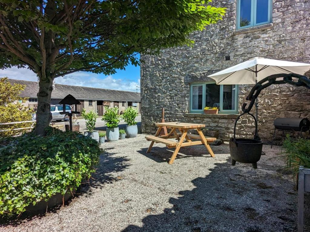 a picnic table and an umbrella in front of a building at 2 Bed in Carnforth oc-90530 in Beetham