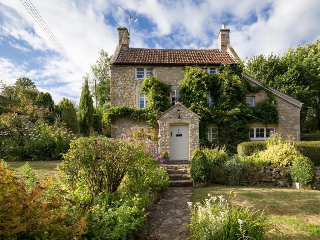 an old stone house with a white door at 3 Bed in Bath oc-skn21 in Wellow