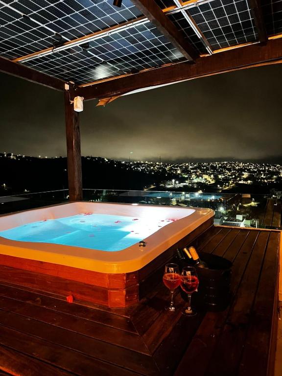 a jacuzzi tub on a deck with wine glasses at Casa de Campo Espetacular com Jacuzzi bem quentinha em Gravatá in Gravatá