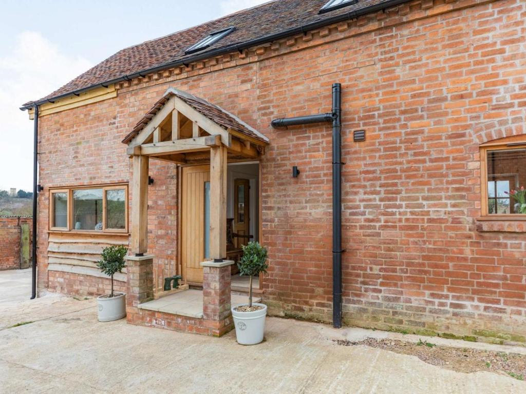 a brick building with an open door with potted plants at 3 Bed in Pershore oc-86760 in Eckington