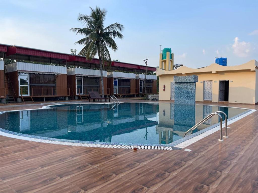 a large swimming pool in front of a building at Sheoak Retreat Tajpur in Tajpur