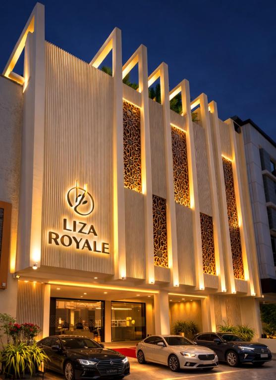 a hotel with cars parked in front of it at Liza Royale Hotel Near Chennai central Railway Station in Chennai